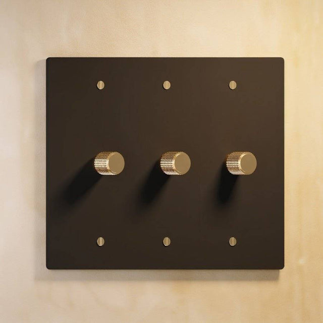 Three-gang matte black The Brass Dimmer Switch - Open Box with brass knobs, perfect for modern home lighting.