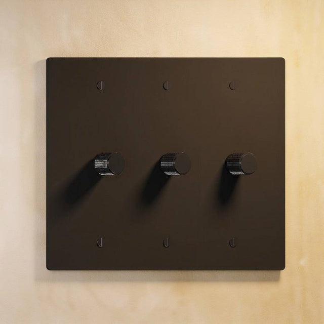 Three-gang matte black The Brass Dimmer Switch - Open Box with uniform finish, ideal for sleek lighting setups.