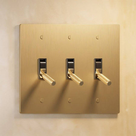 Triple gang The Brass Toggle Switch (1 to 5 Gang) - Open Box with brushed brass plate and three toggles, ideal for coordinated lighting control.