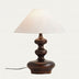 Table lamp with dark bronze base and cream fabric shade on neutral background.