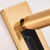 "A close-up detail of a gold wall lamp with a rectangular base and a cylindrical spotlight, showing the adjustment mechanism and finish."
