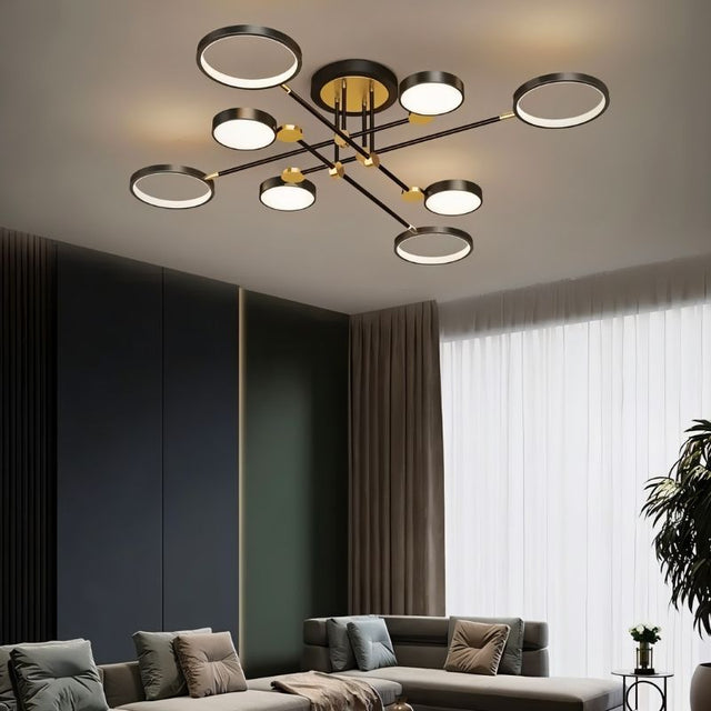"A modern ceiling light with multiple circular lights and black metal accents installed in a living room with a gray couch and white curtains."