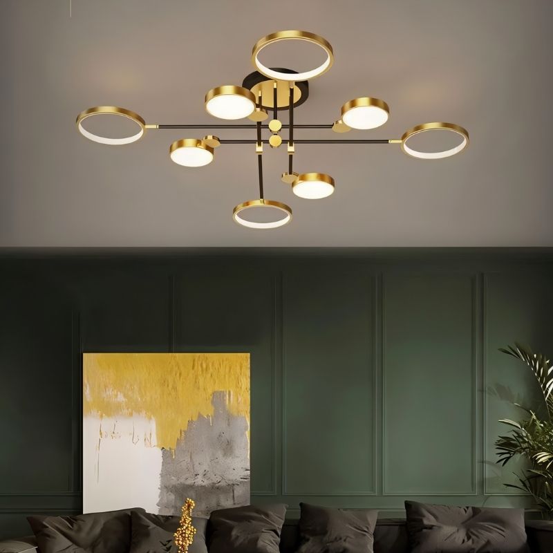 "A modern ceiling light with multiple circular lights and black metal accents installed in a living room with a dark green wall and artwork."