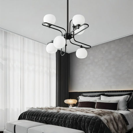 "A modern chandelier with spherical glass shades and a black metal frame in a contemporary bedroom."