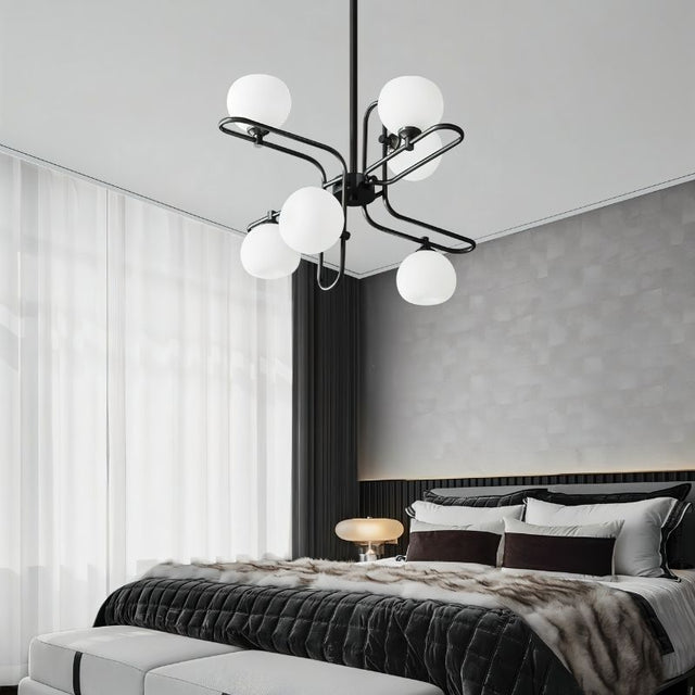 "A modern chandelier with spherical glass shades and a black metal frame in a contemporary bedroom."