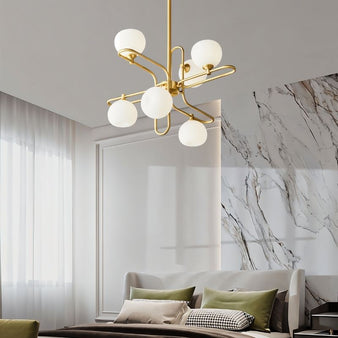 "A modern gold chandelier with spherical glass shades in a contemporary bedroom interior."