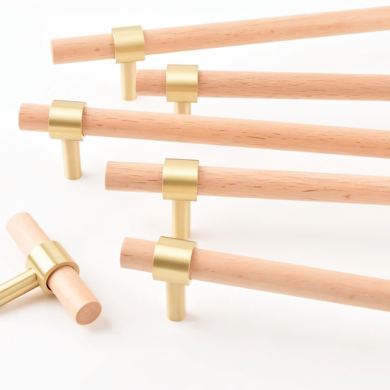 "light wood pull bars with brass accents arranged in multiple sizes, modern cabinet hardware."
