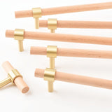 "light wood pull bars with brass accents arranged in multiple sizes, modern cabinet hardware."