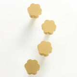 "Set of four gold brass floral knobs with brushed finish on a white background."
