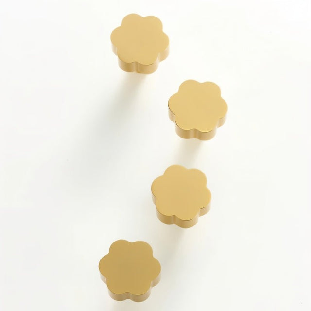 "Set of four gold brass floral knobs with brushed finish on a white background."