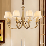 Uloma Chandelier – Elegant Lighting For Luxe Interiors hanging above a dining table in a warmly lit traditional interior.