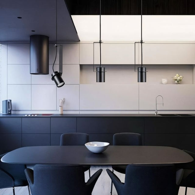 "Pendant lights with cylindrical shades, one oblique and two straight, illuminating a modern kitchen and dining area."