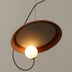 Pendant light with terracotta ceramic shade and glowing sphere, suspended against neutral background.