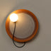 Pendant light with amber glass shade and illuminated white orb, displayed against neutral gray wall.
