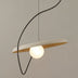 Pendant light with curved black metal frame, cream and wood shade, and glowing white sphere, suspended against neutral gray background.