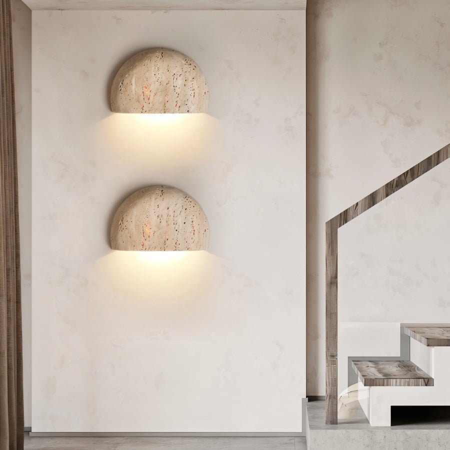 "Pair of travertine wall lamps illuminating a modern hallway and staircase with a soft, downward glow."