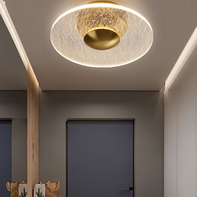 "A ceiling light with a cracked-glass effect diffuser, illuminating a modern hallway with soft ambient light."