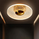 "A ceiling light with a cracked-glass effect diffuser, providing ambient illumination in a modern hallway."