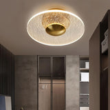 "A flush-mount ceiling light with a cracked-glass effect diffuser, providing ambient illumination in a modern room."   