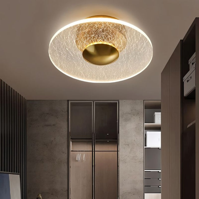 "A flush-mount ceiling light with a cracked-glass effect diffuser, providing ambient illumination in a modern room."   