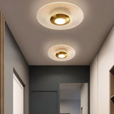 "Two patterned ceiling lights with a modern design, providing ambient illumination in a hallway."
