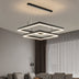Modern black metal square pendant chandelier with integrated LED lighting suspended above a gray sofa in a contemporary living room.