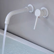Matte white Vartay Bathroom Faucet with water running, wall mounted above a bathtub for a clean modern aesthetic.