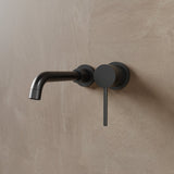Matte black Vartay Bathroom Faucet with wall-mounted installation and modern cylindrical handle for contemporary bathrooms.