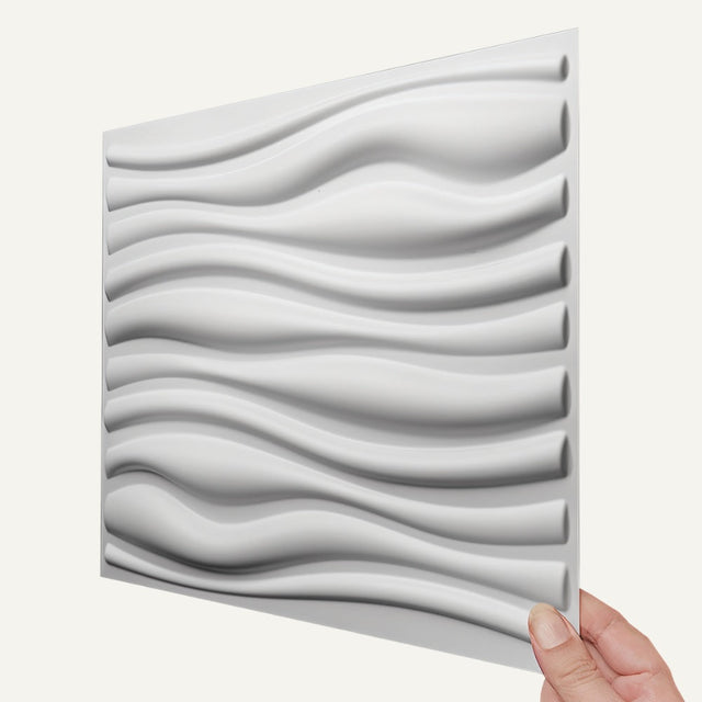Vefni Panels - Durable, Modern Design for Any Space. Close-up of a single white Vefni PVC wall panel with modern 3D wave design held by hand.