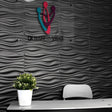 Vefni Panels - Durable, Modern Design for Any Space. Black 3D PVC wall panels with wave texture installed in a modern office reception area.