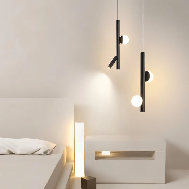  "Two sleek iron and acrylic pendant lights with cylindrical rods and glowing orb accents hang in a minimalist modern bedroom."