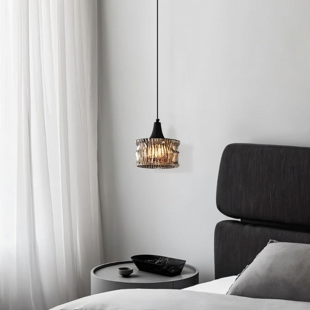 "A pendant light with a rippled glass shade providing ambient lighting in a bedroom."
