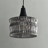 "A pendant light with a rippled glass shade and black cord."