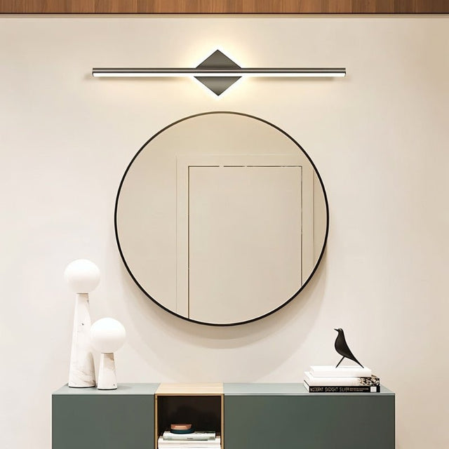 "A modern black wall lamp with a diamond-shaped base and horizontal bar, mounted above a round mirror in a contemporary bathroom with a minimalist aesthetic."