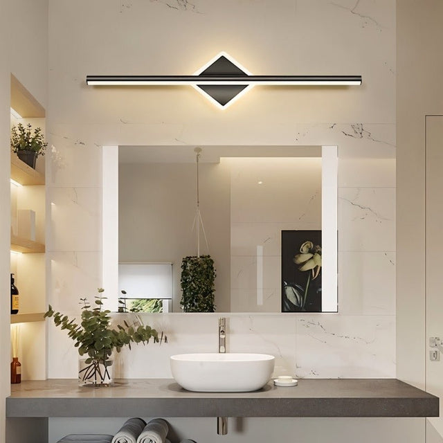 "A modern black wall lamp with a diamond-shaped base and horizontal bar, mounted above a rectangular mirror and a white vessel sink in a contemporary bathroom with marble walls."