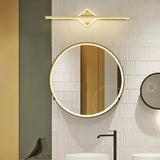 "A modern gold wall lamp with a diamond-shaped base and horizontal bar, mounted above a round mirror in a contemporary bathroom with textured walls, providing focused illumination and a sleek design."