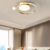 "A gold LED ring ceiling light with intertwined rings in a modern bedroom."