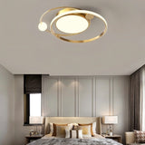 "A gold LED ring ceiling light with intertwined rings in a bedroom."