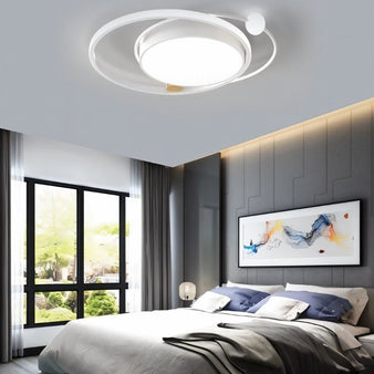 "A white LED ring ceiling light with intertwined rings in a modern bedroom."