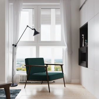 "Modern black floor lamp with adjustable angular arm and conical shade, placed in a bright living room with a large window and a green accent chair."