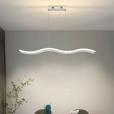 "A modern LED pendant light with an undulating wave design, illuminating a dining room with a plant and table setting."