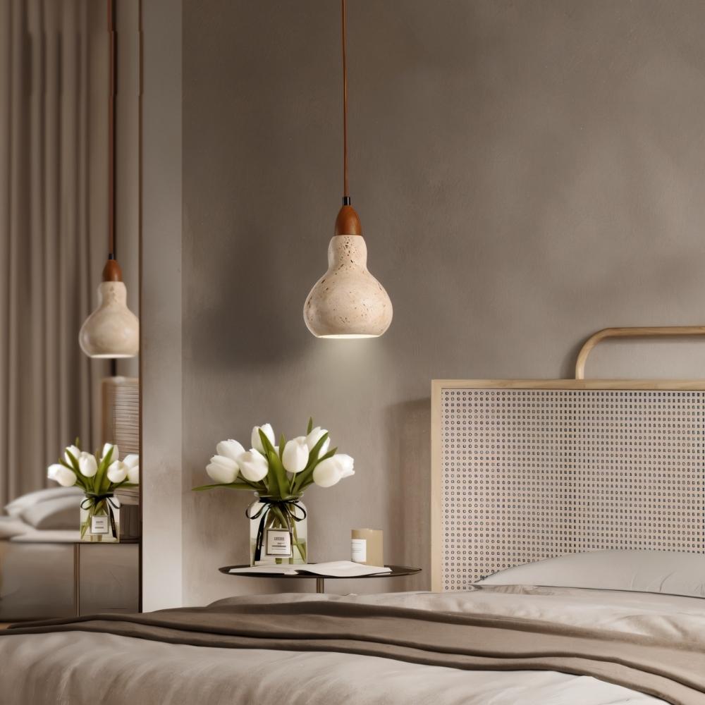 "A travertine pendant light hanging in a bedroom with a bed and flowers."