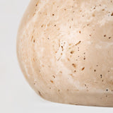 "Close-up of the natural stone texture on a travertine pendant light."