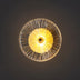 Pendant lamp with yellow pleated shade and metal frame casting warm light against dark background.