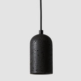 "Modern cylindrical pendant light crafted from black travertine, showcasing its natural, textured surface."