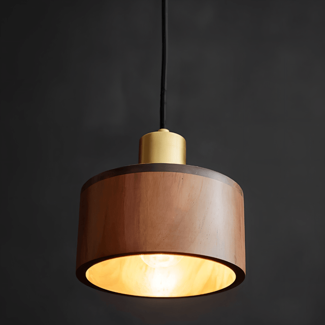 Vesil Copper & Wood Pendant Light Fixture illuminated in a dark setting, highlighting its warm glow and brass accent.