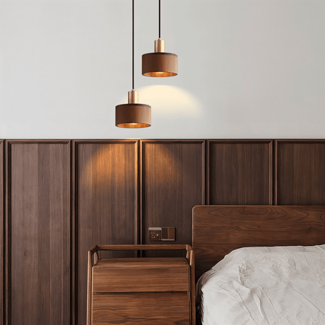 Vesil Copper & Wood Pendant Light Fixture hanging above a wooden nightstand in a modern bedroom with warm ambient lighting.