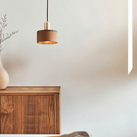 Vesil Copper & Wood Pendant Light Fixture above a minimalist wooden cabinet, ideal for bedroom or living room ambiance.
