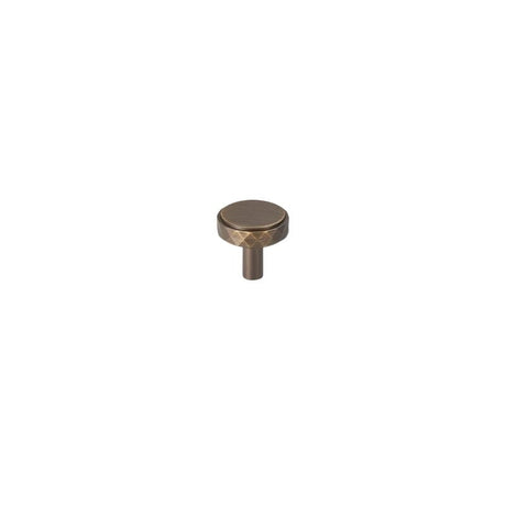 "An antique brass faceted knob with a diamond-cut texture, isolated on a white background."