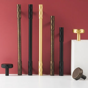 "Assortment of modern faceted brass knobs and pull bars in various finishes with a diamond-cut texture, suitable for contemporary and classic interiors."